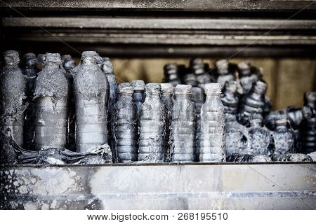 Close Up Damaged Supermarket Glass Plastic Bottles On Shelves After Arson Fire With Burn Black Dark 