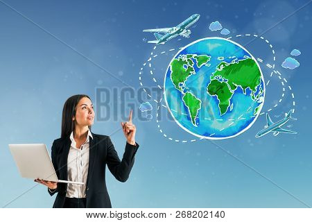 Attractive European Businesswoman Pointing On Blue Background With Travel Globe With Ariplane Sketch