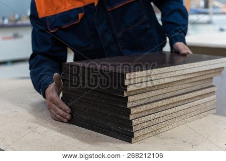Furniture production concept: man working at furniture factory