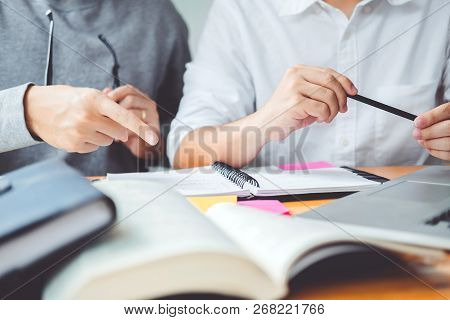 High School Or College Students Studying And Reading Together In Library
