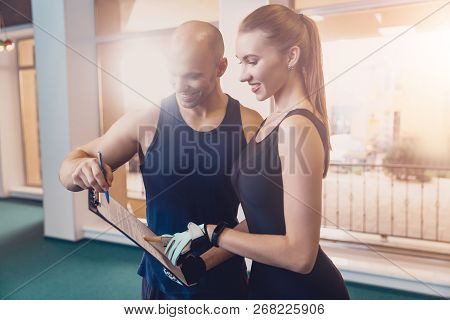 Trainer Writes A Fitness Program Training The Girl. The Program Of Physical Training For Effective R