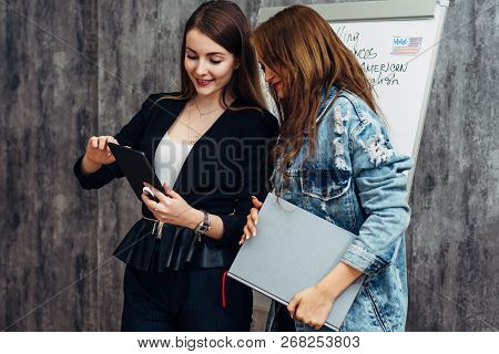 Female Teacher And Student Looking At Screen Of Tablet Pc Using Application.