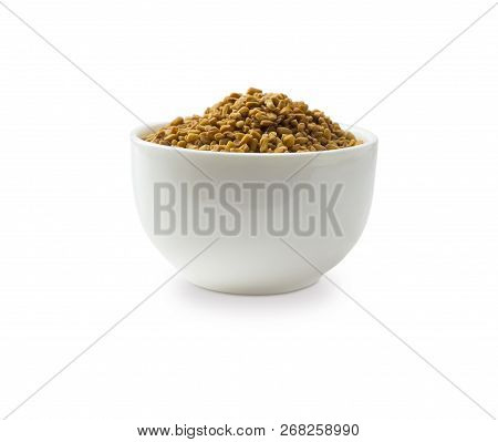 Fenugreek Seeds In A Wooden Bowl Isolated On White. Fenugreek Seeds Isolated On White Background. Fe