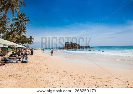 Mirissa Beach, Sri Lanka - JAN 2, 2017:  Tourists on the sand while enjoying the view across the wonderful beach of Mirissa on Jan 2, 2017. Sri Lanka.