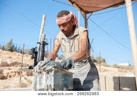  Man making brick from concrete mix.Zarqa-Jordan. 22/7/2013