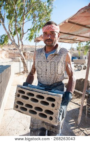 Man making brick from concrete mix.Zarqa-Jordan. 22/7/2013