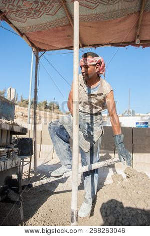 Man making brick from concrete mix.Zarqa-Jordan. 22/7/2013