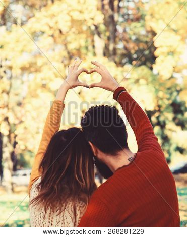 Man And Woman Turned Backwards On Autumn Trees Background.