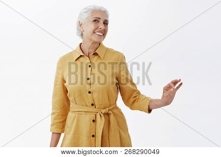 Indoor Shot Of Happy Stylish And Pretty Elegant Senior Woman In Trendy Yellow Coat Posing With Elleg