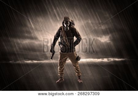 Terrorist in a stormy space with gas mask on his hand and weapons on his arm