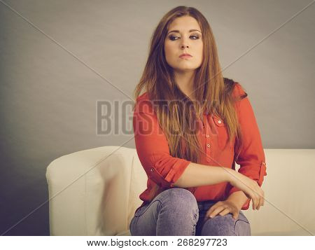 Angry, Pissed Off Young Woman. Attractive Female With Long Brown Hair Sitting On Sofa Being Mad And 