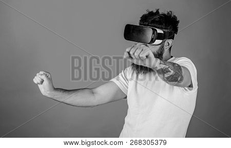 Virtual Racing Concept. Man With Beard In Vr Glasses Driving Motorbike, Red Background. Hipster On C