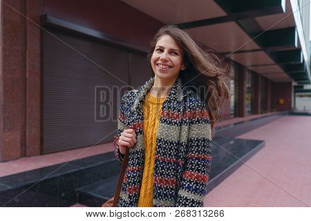 Portrait Of A Smiling Young Woman Walking In European City. New Street Red Pavement And Murble