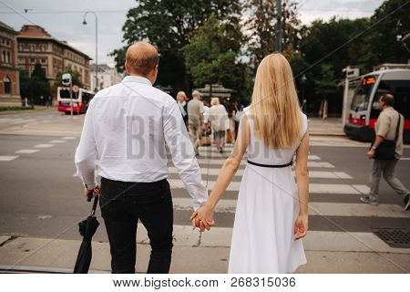 Back View Of Couple. They Are Walking In The Cente Of Austia, Viena
