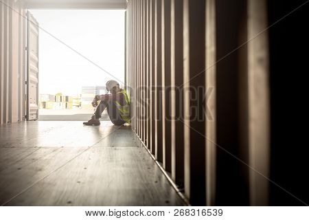 Stressed Despair Staff In Logistic Business Sittng In Container Box At Shipyard