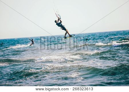 Professional Kiter Makes The Difficult Trick On A Beautiful Background. Kitesurfing Kiteboarding Act