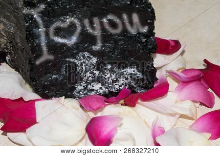 Stone With An Inscription About Love In Rose Petals Background For Design