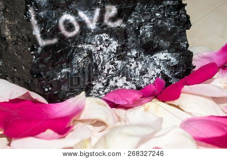Stone With An Inscription About Love In Rose Petals Background For Design