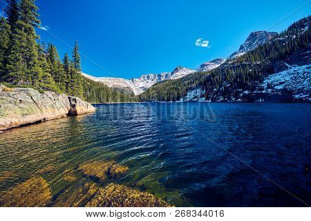 Lake Verna with rocks and mountains around at autumn. Rocky Mountain National Park in Colorado, USA. 
