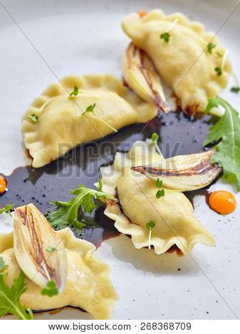 Goose Filled Dumplings With Carmelised Shallots On Black Sauce With Pinch Of 
Cress