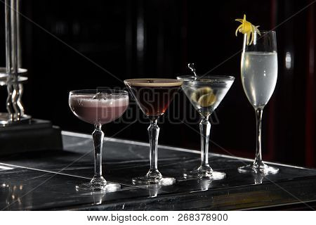 Four Special Cocktails On A Bar Desk. Black Background