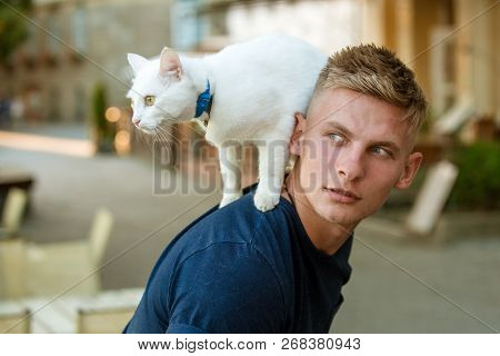 Wanting To Know About Everything. Cat Stands On Back Of His Owner. Happy Man On Walk With Cat Pet. M