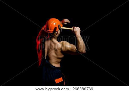 Already Under Construction. Construction Worker Hammer A Nail. Muscular Man Builder At Work Under Co