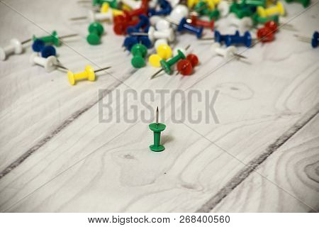 Colorful Thumbtacks On White Wooden Background- Selective Focus On Green Pin