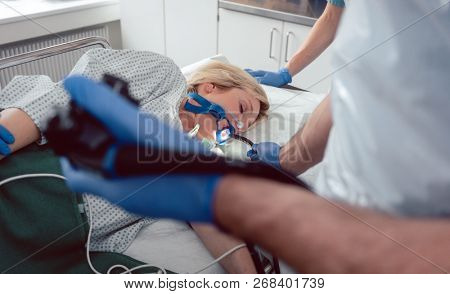 Doctor holding endoscope during gastroscopy in hand while patient is under narcosis