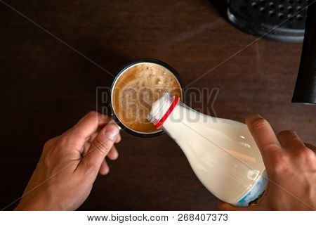 Photo Of Coffee Maker, Mans Hands Pouring Milk Into Mug Of Coffee In Kitchen