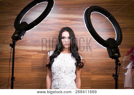 Studio portrait young woman in white dress with ring flash effect. Round LED Circle Lamp