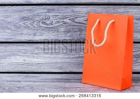 Orange Paper Bag With Copy Space. Gift Packet Of Orange Color On Rustic Wooden Background With Text 