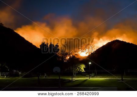 California Fire Burns In Hills Above Suburban Neighborhood Park With Bright Orange Flames In Nightti