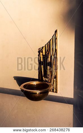Bronce Cross With Holy Water Bowl Attached To The Wall. Entry Way Holy Water Bowl Holder At A Cathol