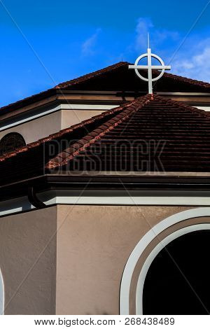 Community Catholic Church Roff Top Close Up View Of A Metal Cross With A Blue Sky Background