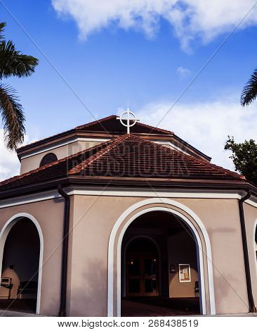 Community Catholic Church Main Entrance To The Chapel With A Blue Sky Background.circular Church Bui