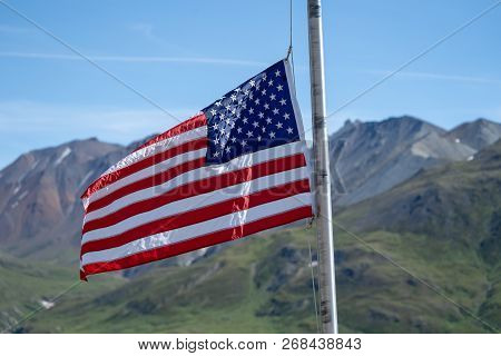 The American Flag Flies In Front Of The Alaska Range Mountains At The Eielson Visitors Center In Den