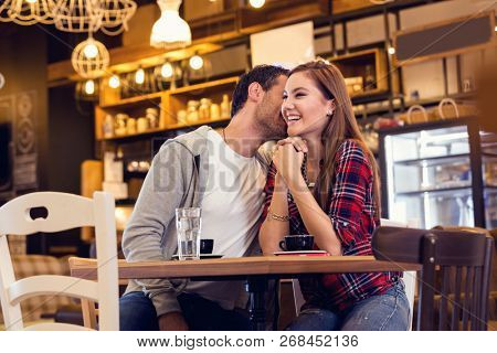 Young couple sitting in cafe and flirting