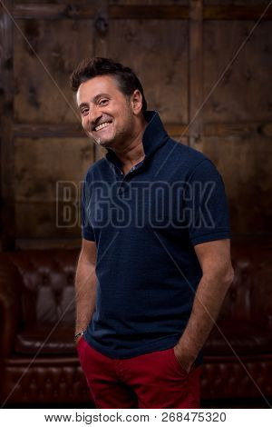 Confident Positive Relaxed Man In Casual Clothes Standing Alone And Putting Two Hands Into The Pocke