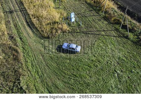 Top View Of A Silver Car Standing On The Lawn. One Flew Over The Car