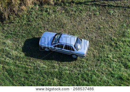 Top View Of A Silver Car Standing On The Lawn. One Flew Over The Car