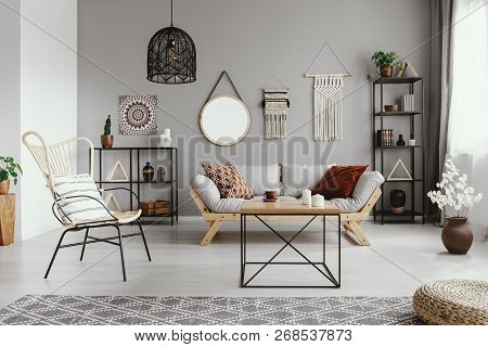 Mirror, Macrame And Graphic On The Grey Wall Of Warm Ethno Living Room With Stylish Furniture And Co
