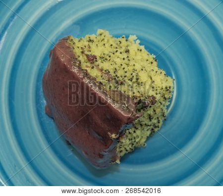 Marijuana Poppy Seed Cake With Chocolate And Fruit Glaze On Blue Plate
