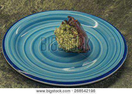 Marijuana Poppy Seed Cake With Chocolate And Fruit Glaze On Blue Plate
