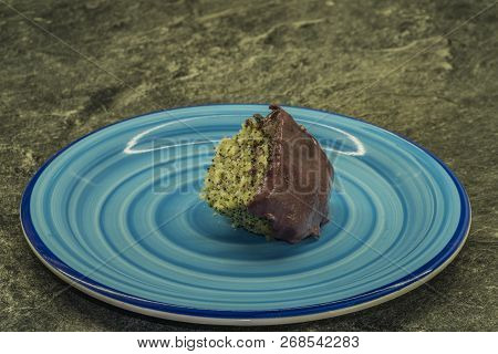 Marijuana Poppy Seed Cake With Chocolate And Fruit Glaze On Blue Plate