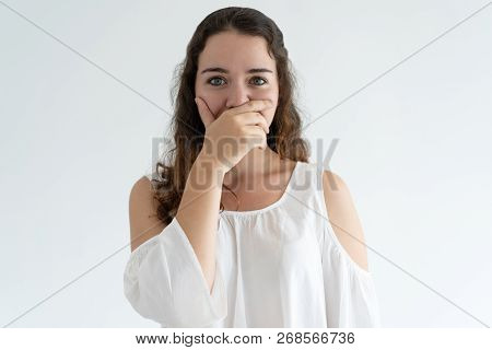 Embarrassed Lovely Woman Covering Mouth With Hand. Young Lady Looking At Camera. Embarrassment Conce