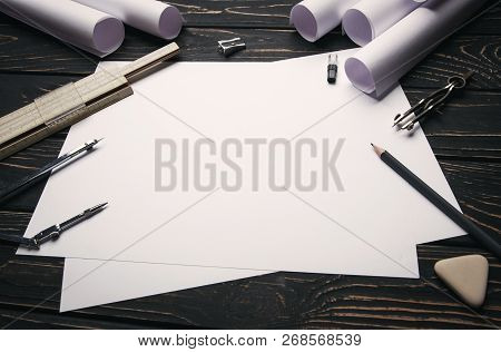 On A Wooden Table Are Drawings, Compasses, Pencil, Elastic, Ruler And Sharpener.