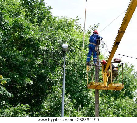 Krasnodar, Russia - August 06, 2018: Electricians Repair The Wires On The Pole With The Help Of A Cr