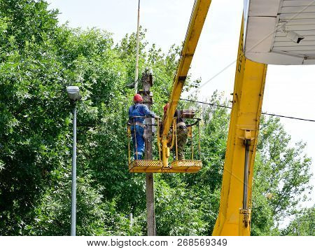 Krasnodar, Russia - August 06, 2018: Electricians Repair The Wires On The Pole With The Help Of A Cr