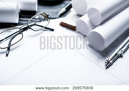 On The Wooden Table There Are Drawings, Compasses, Pencil, Ruler And Glasses.